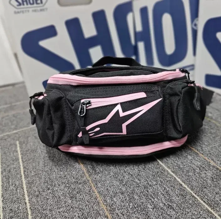 Cangurera Alpinestar negra con lineas rosadas